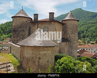 circular towers and tiled roofs of Seix Castle, overlook the town and valley of the Salat in the Ariège Pyrénées, France below Montagne du Cos Stock Photo