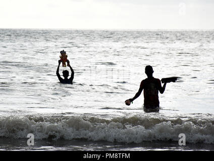 Indian Hindu devotees seen immersing idols during the ten-day long festival. Immersion of elephant-headed Hindu god Ganesha in Arabian Sea at Juhu beach on the one and half day of the ten-day long festival Ganesh Chaturthi in Mumbai.  Hindu devotees bring home idols of Lord Ganesha in order to invoke his blessings for wisdom and prosperity. Stock Photo