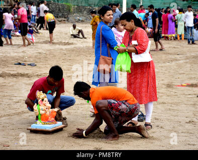 Indian Hindu devotee seen with an idol for immersion during the ten-day long festival. Immersion of elephant-headed Hindu god Ganesha in Arabian Sea at Juhu beach on the one and half day of the ten-day long festival Ganesh Chaturthi in Mumbai.  Hindu devotees bring home idols of Lord Ganesha in order to invoke his blessings for wisdom and prosperity. Stock Photo