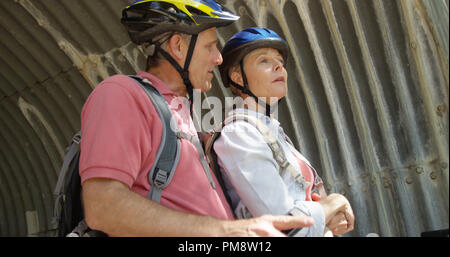 Elderly white couple at the park taking bike break Stock Photo