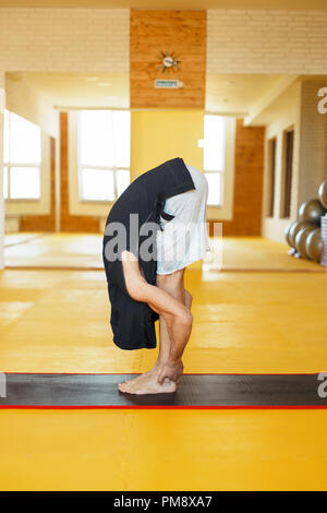 man doing stretching his back in the gym Stock Photo