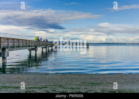 A view of the fishing pier at Dash Point, Washington. Clouds can be seen in the distance. Stock Photo