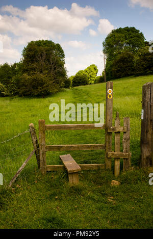 Wooden step over stile on the Winchcome Way footpath in the Cotswolds District of England. Stock Photo