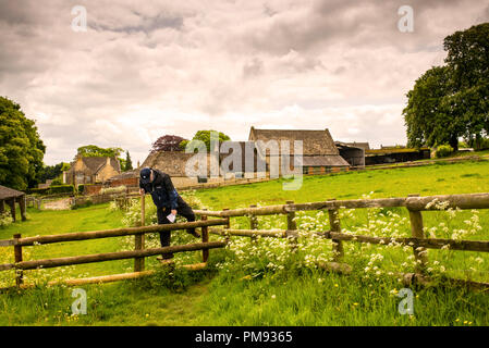 Rights of way in the United Kingdom give walkers rights to roam on designated paths, here crossing over a stile on a farm in the Cotswolds District. Stock Photo