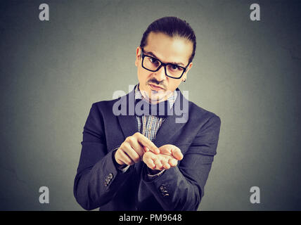 Young serious business man in glasses asking for more money to pay back debt Stock Photo