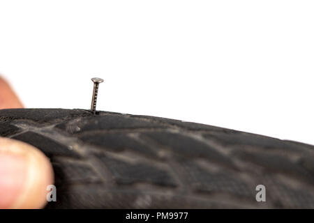 A beaten bicycle tire in the workshop. A bicycle wheel pierced with a nail. Light background. Stock Photo