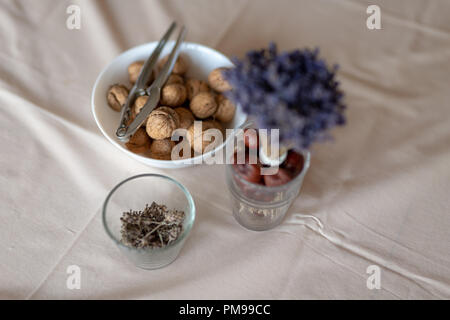 Nutcracker and walnuts in a bowl on a table covered with a tablecloth. Snack on the kitchen table. Light background. Stock Photo