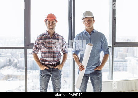 talented handsome architects with blueprint are posing to the camera Stock Photo