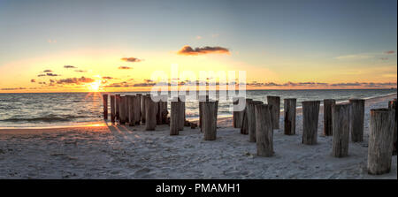 Dilapidated ruins of a pier on Port Royal Beach at sunset in Naples, Florida Stock Photo