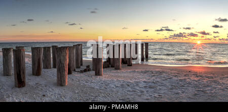 Dilapidated ruins of a pier on Port Royal Beach at sunset in Naples, Florida Stock Photo