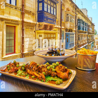 The restaurants of Strait street are best place to enjoy the famous rabbit stew, french fries, mussels and other traditional dishes of Maltese cuisine Stock Photo