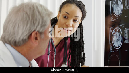 Doctors discussing brain x-rays Stock Photo