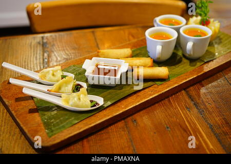 Vegan tomato soup in mini coffee cups and other vegan appetizers served on a board at a catered party Stock Photo