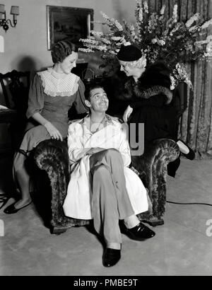 Clark Gable sitting on a chair and surrounded his co-stars from the film 'Red Dust,' Mary Astor and Jean Harlow, circa 1933  File Reference # 33371 568THA Stock Photo