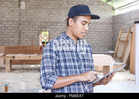 worker at furniture factory working on his pc tablet Stock Photo