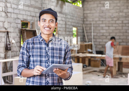 worker at furniture factory working on his pc tablet Stock Photo