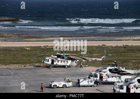 Aircraft and airport staff are seen on the tarmac of the Aden Abdulle airport inside the African Union Mission in Somalia (AMISOM) base in Mogadishu,  Stock Photo