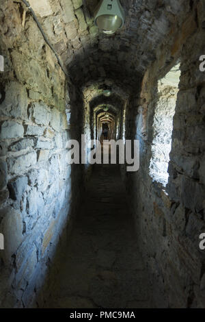 Narrow long corridor in the old stone fortress Stock Photo