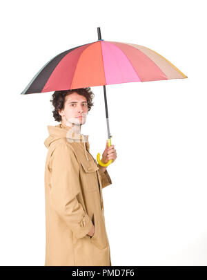 Nice man standing side to camera and keeping his colorful umbrella Stock Photo