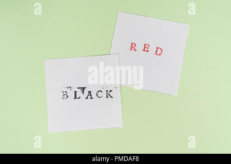 the contrast between the red and black words printed on two sheets of paper Stock Photo