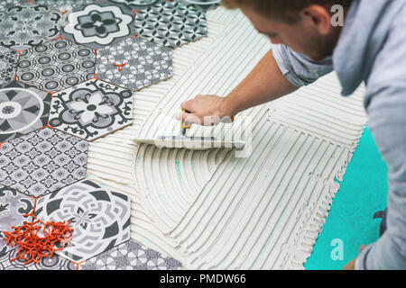 worker applying tile adhesive on the floor Stock Photo