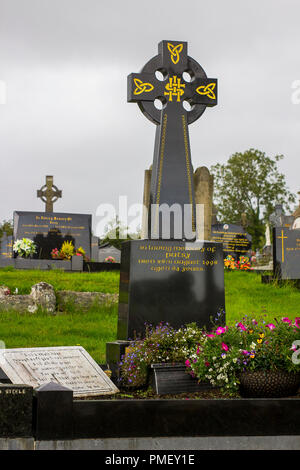 11 September 2018 St John's Roman Catholic Church yard in Magherafelt Northern Ireland with a large black marble Celtic Cross headstone. Stock Photo