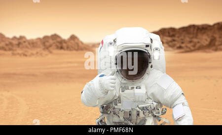 Humans on the planet Mars. Astronaut on Mars shows a thumbs-up. Landscape of the red planet Mars. Spaceman inhabits a new planet Stock Photo