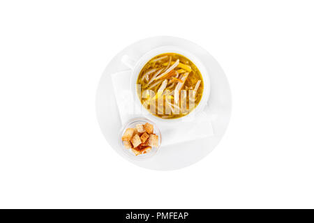 Soup transparent with chicken, fish, noodles in plate isolated white and croutons, dry bread, on a napkin. Serving dishes in a cafe, restaurant, for a Stock Photo