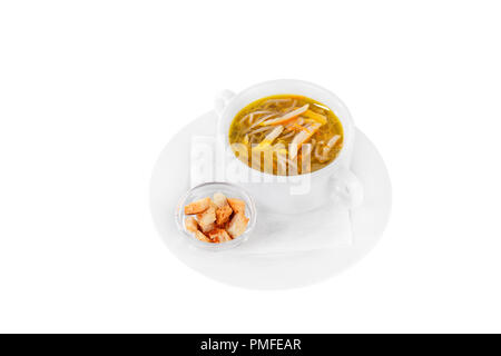 Soup transparent with chicken, fish, noodles in plate isolated white and croutons, dry bread, on a napkin. Serving dishes in a cafe, restaurant, for a Stock Photo