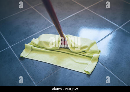 damp wiping tiled floor with floor cleaning cloth Stock Photo