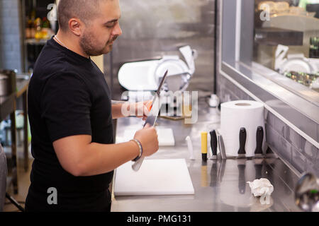 The cook holds sharp knives in his hands. Preparing for cooking. Stock Photo