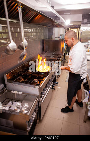 Chef cooking and doing flambe on food in restaurant kitchen , Great cook at work Stock Photo