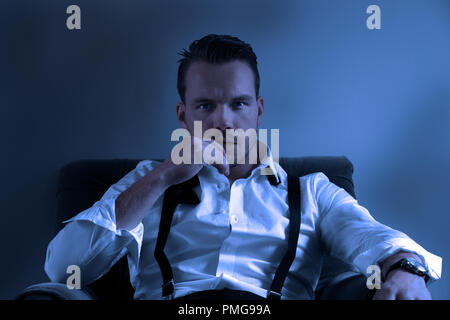 Handsome business man man in hotel room, wearing tuxedo with loose bowtie Stock Photo