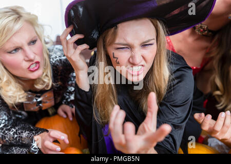Portrait of a funny young woman wearing witch costume during Halloween Stock Photo