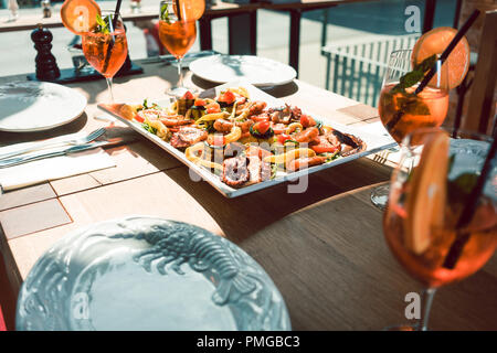 Fresh seafood served with orange cocktails on the table of a trendy restaurant Stock Photo