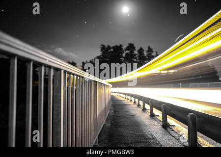 Long exposure shot of the Schiffenen Dam, in the County of Fribourg in Switzerland, with vehicle light trails on the side Stock Photo