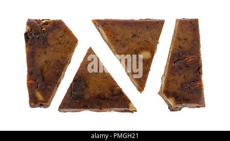 Pieces of an almond, cashew and date chocolate protein bar isolated on a white background. Stock Photo