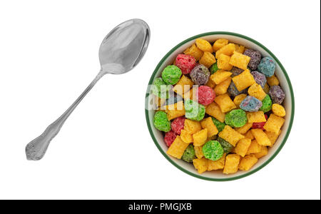 Top view of a bowl of generic fruit flavored breakfast cereal with a spoon to the side isolated on a white background. Stock Photo