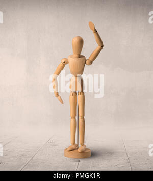 Wooden mannequin posed in front of a greyish background Stock Photo