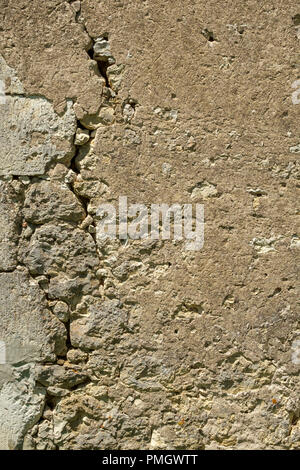 A large crack in the wall of a rustic outbuilding threatens its stability. Stock Photo