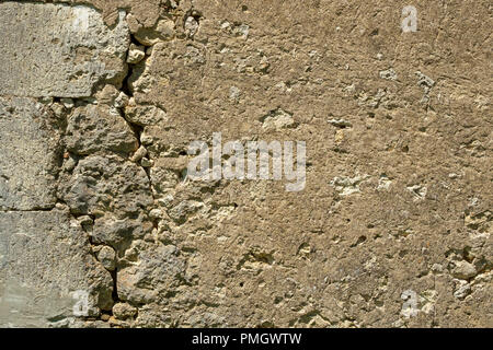 A large crack in the wall of a rustic outbuilding threatens its stability. Stock Photo