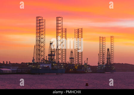 Jack up rigs oil and gas industry in the Port of Dundee, Scotland. UK Weather Sep 2018.  Colourful start to the day at Tayside Docks where three jack-up rigs, oil rig platforms are undergoing service and maintenance at the riverside facility on the River Tay estuary.  The slowdown in the North Sea oil and gas industry has led to oil rigs being removed from the North Sea, with Dundee docklands providing a berthing place for them until they are required again in the future. Credit; MediaWorldNews/AlamyLiveNews. Stock Photo