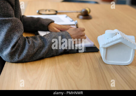businesswoman write note with house model at law firm Stock Photo - Alamy