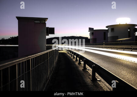 Long exposure shot of the Schiffenen dam in the county of Fribourg, in Switzerland, with vehicle light trails on the side Stock Photo