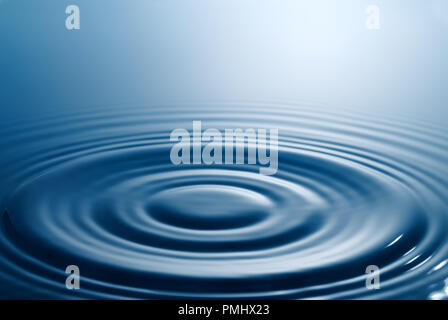 Tranquil scene. Symmetrical smooth circles and waves on water surface after splash. Stock Photo