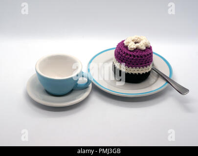 white and blue porcelain cup and crocheted torte at plate Stock Photo