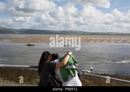 A couple hug while looking out across the estuary at low-tide of the River Dovey, on 12th September 2018, in Aberdovey, Gwynedd, Wales. Stock Photo