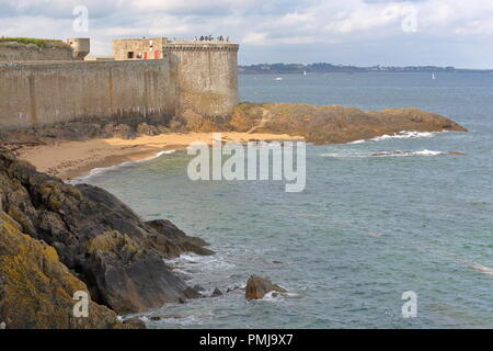View of the Bidouane Tower, located along the ramparts inside the walled city of Saint Malo, Brittany, France, with the rocky coast in the foreground Stock Photo