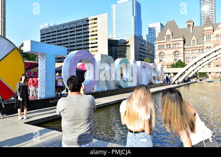 People take photos in front of 'Toronto' Sign in Phillips Square in Downtown Toronto, Canada Stock Photo