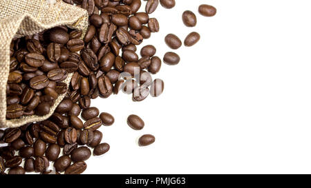 Burlap sack overflowing with coffee beans and into white surface background. With copy space. Stock Photo